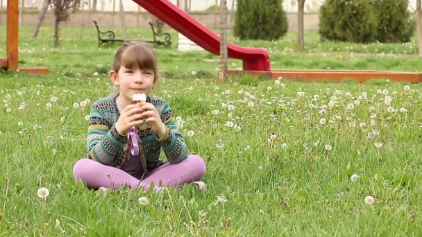 meisje, zittend op het gras en ijs eten - Video