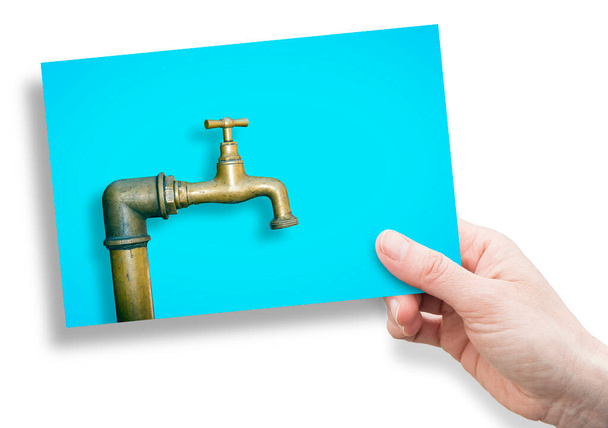 Détail d'un robinet en laiton isolé sur fond couleur unie - Concept avec main tenant une carte postale - Photo, image