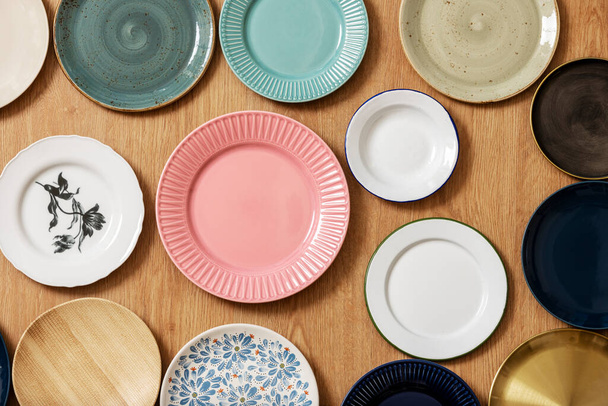 Ensemble de assiettes en porcelaine vide assorties de différentes formes et couleurs - Photo, image