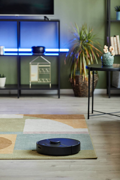 Vertical background image of robot vacuum cleaner in smart home with led light setup, copy space - Φωτογραφία, εικόνα