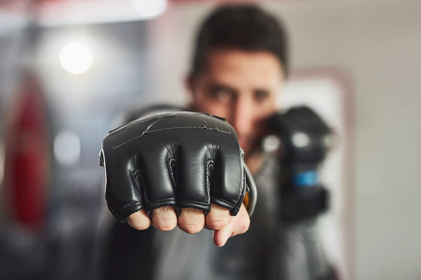 Coming at you full force. Cropped portrait of a professional fighter training in the gym. - Foto, immagini