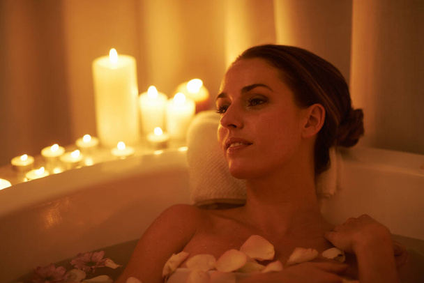 Ortam rahatlatıcı ve sıcak bir banyo. Muhteşem bir kadının mum ışığında rahatlarken çekilmiş bir fotoğrafı.. - Fotoğraf, Görsel