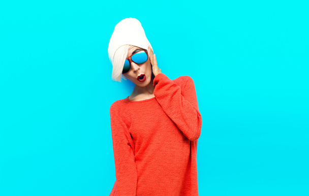 Portrait sexy blond model in red sweater on blue background. Stu - Photo, image