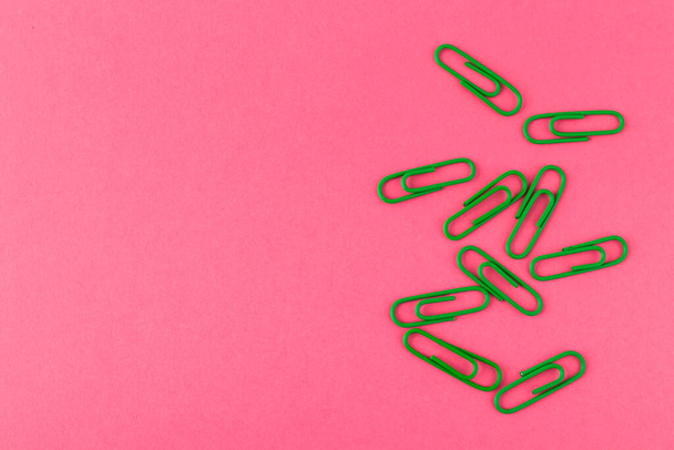 Colored paper clips. Green paper clips macro close up isolated on a pink background with copy space. - Fotoğraf, Görsel
