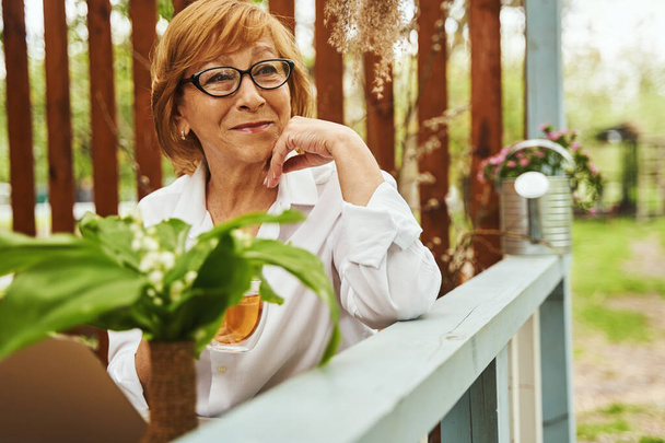 Calm beautiful woman drinking tea on terrace - Valokuva, kuva
