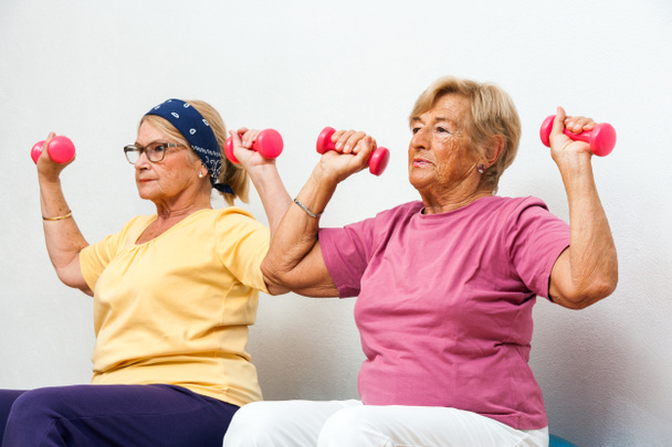 Chicas mayores de fitness haciendo ejercicio con pesas
. - Foto, imagen