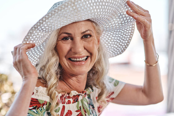 Me siento tan bonita con este sombrero. Retrato recortado de una atractiva mujer mayor sonriendo mientras está al aire libre en un día de verano. - Foto, imagen