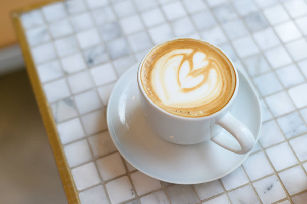 Hot cappuccino with latte art on table - Photo, Image