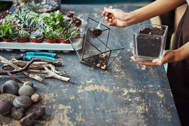 Florist filling a terrarium container with the potting mix - Photo, image