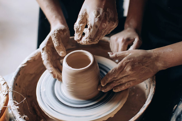 Hands of potter do a clay pot.The view from the top. - 写真・画像