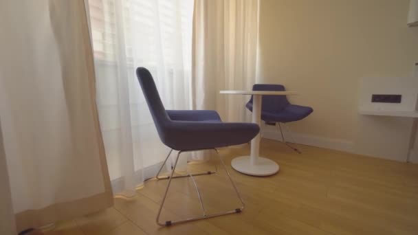 neuer moderner Tisch mit Stühlen steht im Hotelzimmer in einer Wohnung am Fenster. - Filmmaterial, Video