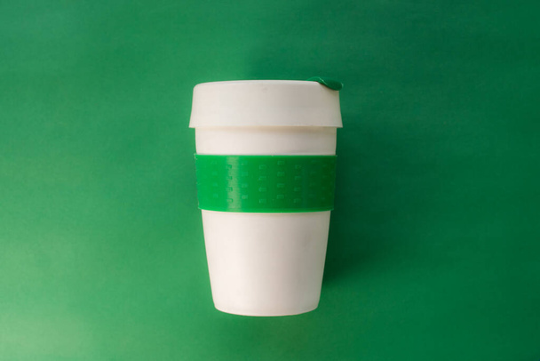 Plastic thermos for hot drinks on green background - Photo, Image