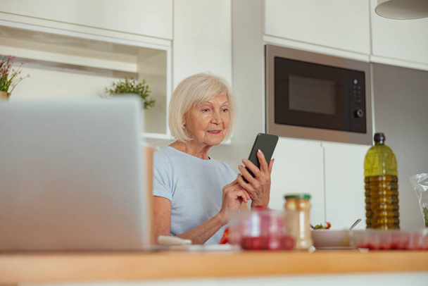 Femme retraitée se reposant à la cuisine confortable de la maison - Photo, image