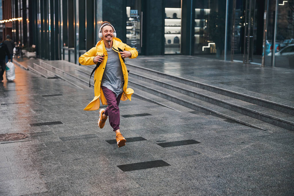 Merry stylish guy running to happiness in city - Zdjęcie, obraz