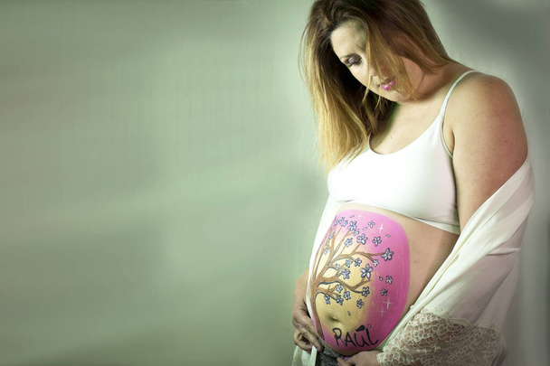 Eight month pregnant woman holding her drawn belly. Tranquil scene - Fotografie, Obrázek