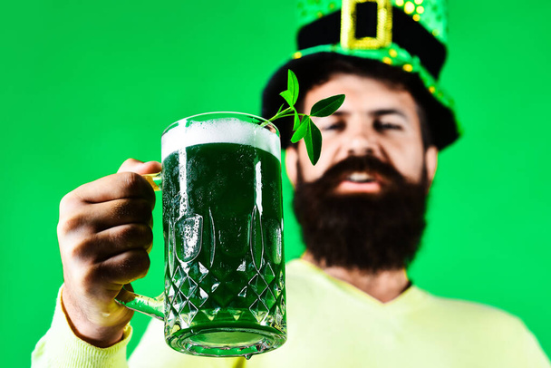 Patricks Day publicité. Heureux homme barbu avec tasse de bière verte. Clover dans un verre de bière. - Photo, image