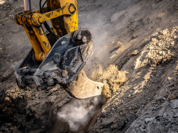Excavadora desgarrador accesorio rasgando suelos congelados en el sitio de construcción - Foto, imagen