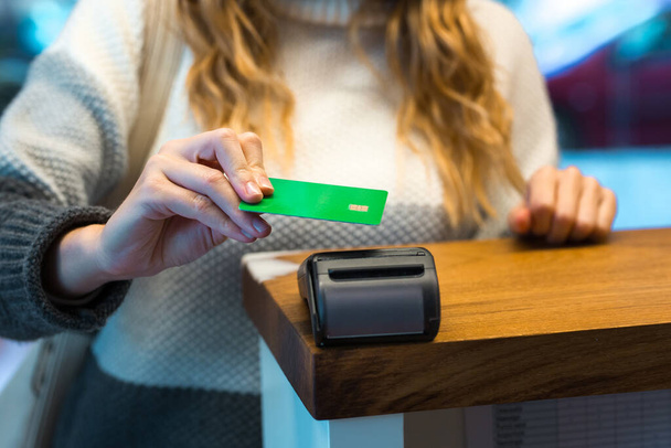 Frau bezahlt mit Kreditkarte über Terminal - Foto, Bild