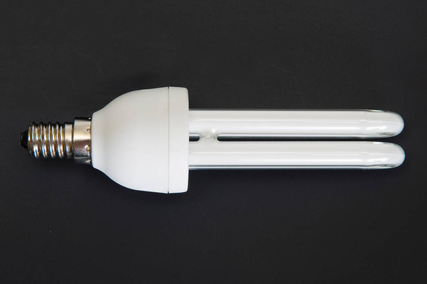Lampe fluorescente à économie d'énergie lumineuse sur fond de cuisson noir - Photo, image