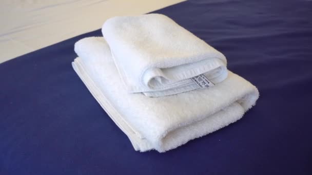 Fehér törölköző az ágyon a vendégszobában a szálloda ügyfeleinek. - Felvétel, videó