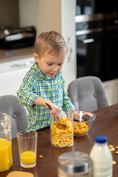 Child preparing a healthy breakfast in the kitchen - Foto, afbeelding