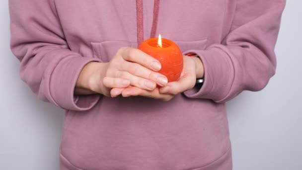 Жінка або дівчина тримає в руках червону кругову палаючу свічку. Відео-банер з роздільною здатністю 4k з палаючою свічкою
. - Кадри, відео
