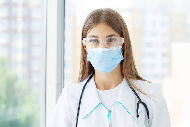Jeune infirmière à la caméra portant un masque chirurgical - Photo, image