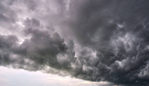Landschap van donkere onheilspellende wolken die zich vormen op stormachtige hemel tijdens zware onweersbui - Foto, afbeelding