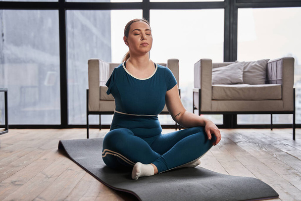 Caucasian woman with amputee arm meditating at home in the morning and practicing yoga - Foto, Imagem