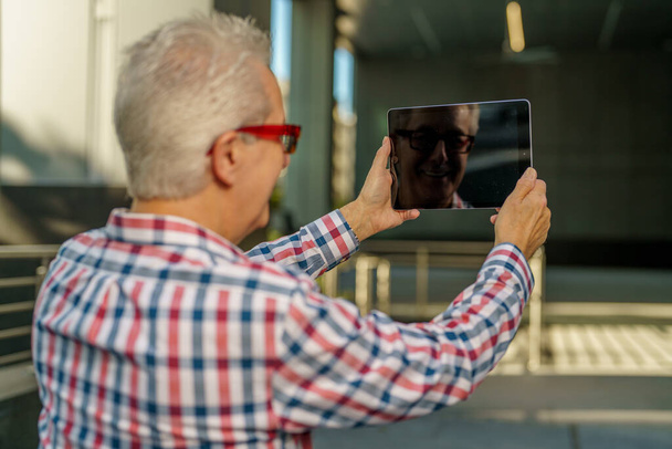Mans αντανάκλαση σε μια μαύρη ψηφιακή οθόνη tablet - Φωτογραφία, εικόνα