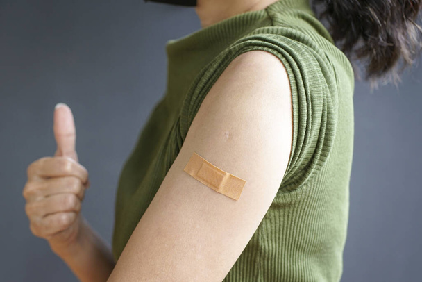 Close up view of woman arm with bandage, getting vaccinated immunity. Inoculation, vaccination, vaccinated patient concept. - Fotó, kép