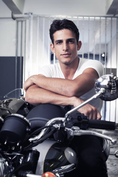 Want to go for a joyride. A handsome young man sitting on his motorcycle. - Foto, afbeelding