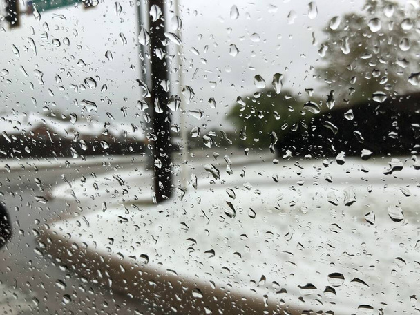 冬の午後に車のフロントガラスに降る雨の作物のショット - 写真・画像