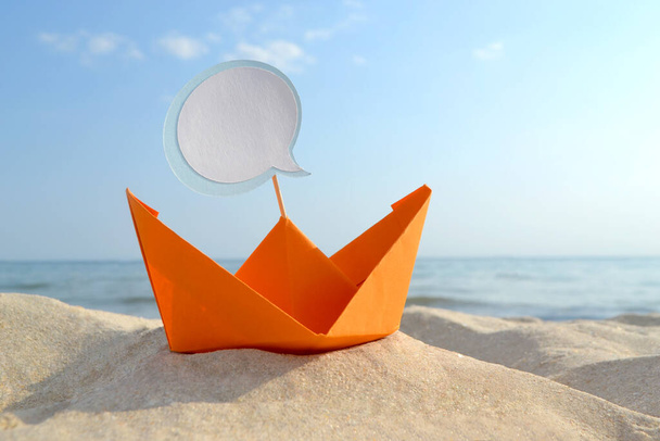 砂浜のオレンジペーパーボート背景の紙からクローズアップ小型ボート - 写真・画像