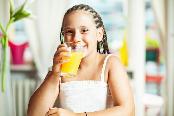 Young girl drinking orange juice - Fotoğraf, Görsel