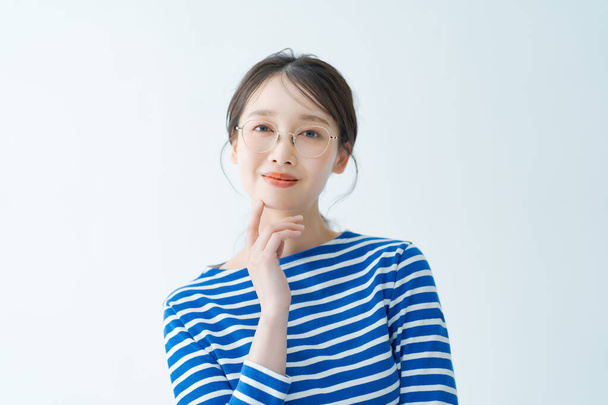 Νεαρή γυναίκα με μεταλλικά γυαλιά και λευκό φόντο - Φωτογραφία, εικόνα
