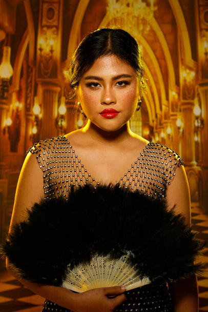 20 'li yaşlarda güzel çilli ve tombul vücutlu seksi Asyalı kadın saray köşkünde özel bir parti için altın sarısı ışığın üzerine kristal şehvetli elbiseler giyer. - Fotoğraf, Görsel