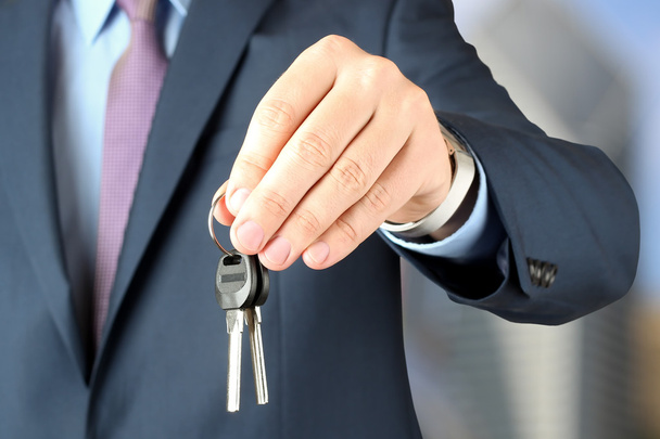 Imagem cortada do agente imobiliário dando chaves de casa no escritório
 - Foto, Imagem