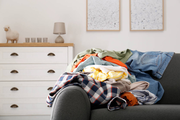 Oturma odasındaki kanepede kirli giysiler yığını. Yöntem düzenleniyor - Fotoğraf, Görsel