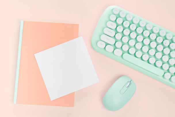 plat lay groene kleur toetsenbord en briefpapier op oranje backgroun - Foto, afbeelding