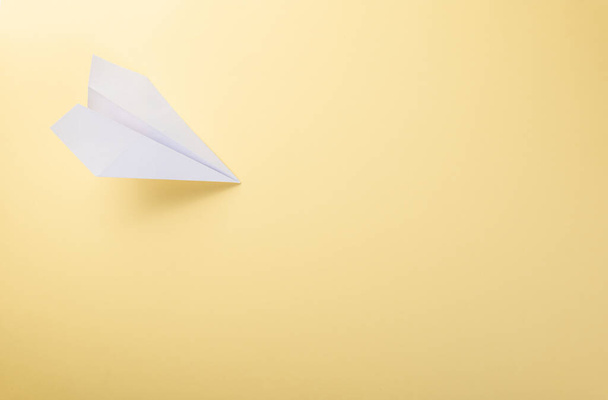 Paper plane letter document message. Top view mock up design of airplane travel tourism, isolated on yellow background with blank empty space for copy space - Valokuva, kuva