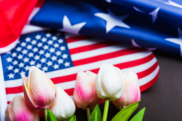 Happy Memorial Day Remember previously but now seldom called Decoration Day, American flag and a Tulip flower on a black background and copy space, a federal holiday in the United States - Photo, image