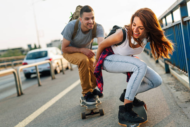 attractive couple riding skateboards  - Foto, Imagen