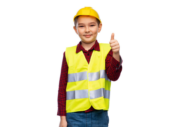 happy boy in construction helmet showing thumbs up - Фото, изображение