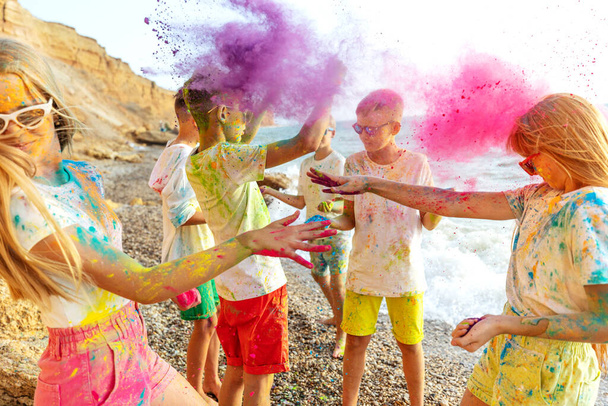 Los niños juegan en la naturaleza. Colores Holi. - Foto, imagen