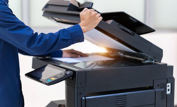 İşadamı, yazıcı fotokopi ağı panelindeki düğmeye basar, ofis konseptinde fotokopi üzerinde çalışır, yazıcı, kağıt tarama ve kopyalama için ofis çalışanı ekipmanıdır. - Fotoğraf, Görsel