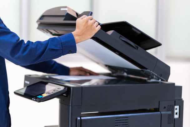 Bouton de presse d'homme d'affaires sur le panneau du réseau de photocopieur d'imprimante, travaillant sur des photocopies dans le concept de bureau, imprimante est équipement d'outil d'employé de bureau pour numériser et copier le papier. - Photo, image