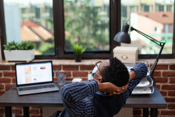 Väsynyt startup yrityksen omistaja venyttely ja tauolla työskentelevät kannettavan tietokoneen - Valokuva, kuva