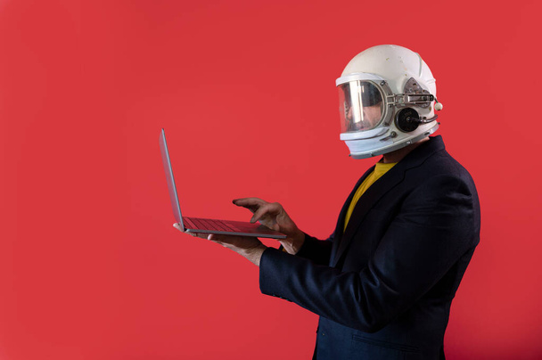 Бізнесмен з шоломом космонавта за допомогою ноутбука
 - Фото, зображення