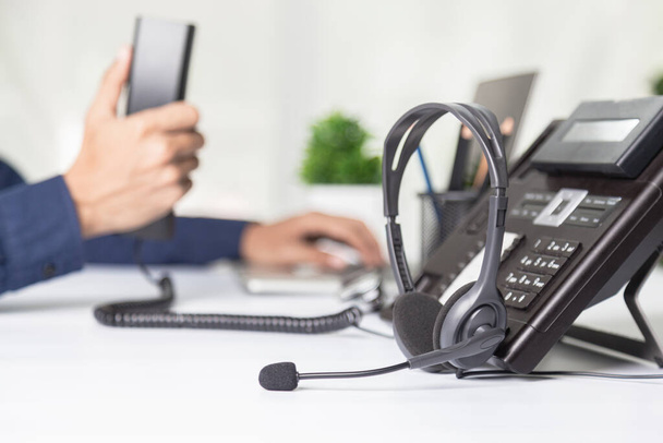 De medewerker van het callcenter wijst naar het knopnummer op de telefoonbalie, de communicatieondersteuning, het callcenter en de helpdesk van de klantenservice. voor (call center) concept - Foto, afbeelding